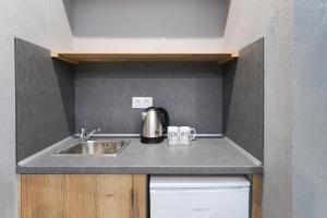 un bancone della cucina con un lavandino e un bollitore sopra di Meni Studios a Limenaria