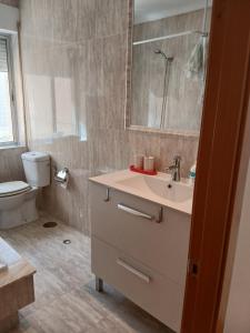 a bathroom with a sink and a toilet and a mirror at Cecilia in Muros