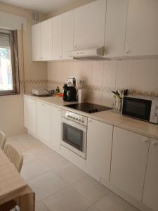 a kitchen with white cabinets and a stove top oven at Cecilia in Muros