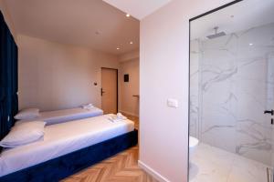a bedroom with a bed and a glass shower at Hotel Almar in Sarandë +249 photos