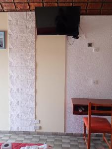 a room with a wall with a tv on a wall at Hotel El Colonial in San Antonio Oeste
