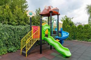 a childrens playground with a slide and an umbrella at Restauracja i Hotel KUBUŚ in Bełchatów