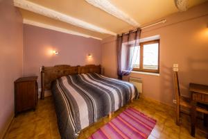 1 dormitorio con cama, ventana y alfombra en Gîte de Rouayras, en Nages