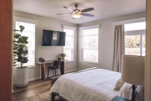 a bedroom with a bed and a desk and windows at Ranch House at Galway Downs in Temecula