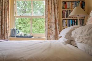 a bedroom with a bed and a book shelf with a window at Orchard Cottage in Ripon +12 photos
