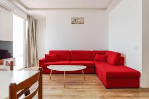 a living room with a red couch and a table at Hotel Maresol Accommodation in Shëngjin