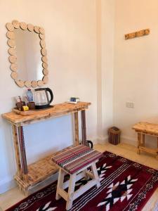 a wooden table with a mirror and a stool at DANA First View Hotel in Dana