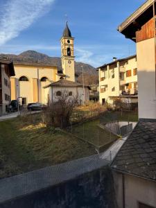 a church with a clock tower in a town at Appartamento Nicoletta in Portolo