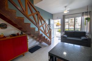 a living room with a staircase and a couch at Apto Novo Duplex em Juqhey in Juquei
