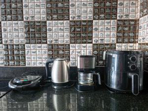 two coffee pots and cups on a counter in front of a wall at Apto Novo Duplex em Juqhey in Juquei +19 photos