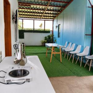 a room with a table and chairs and grass at Zoldyck Villa 1 in Bacolod