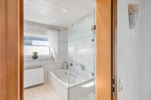 a white bathroom with a tub and a shower at Zipper Burgblick Otzberg Odenwald in Hering +31 photos