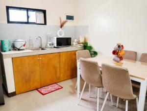 a kitchen with a table and chairs in a kitchen at Zoldyck Villa 1 in Bacolod