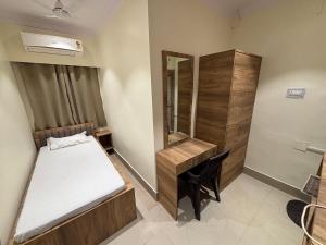 a small bedroom with a bed and a mirror at Hotel mansurya in Jamshedpur