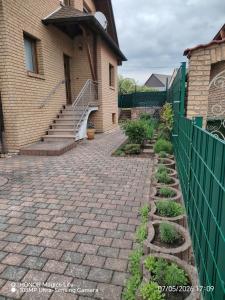 a brick walkway in front of a house with a fence at Ferienwohnung Am Wald in Bad Marienberg