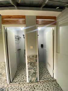 a bathroom with a mirror and a walk in shower at corak alam glamping in Tangkubanperahu