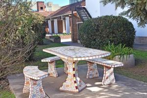 a picnic table and two benches in front of a house at Residencial Garcia in Embalse