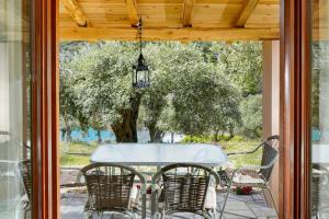 a table and chairs on a porch with a tree at Giola Bungalows Sirines in Astris