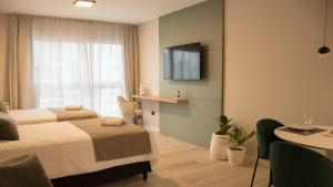 a hotel room with a bed and a television at VAYU LuxuryLofts in Bahía Blanca