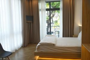 a bedroom with a bed and a large window at Serene Residence in Vientiane