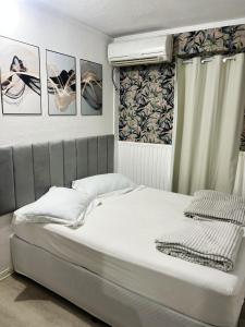 a bed in a bedroom with pictures on the wall at Hospedagem Doce lar in Joinville