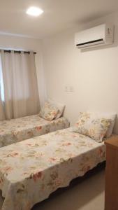 a bedroom with two beds and a air conditioner at Ocean garden in Cabo Frio +15 photos