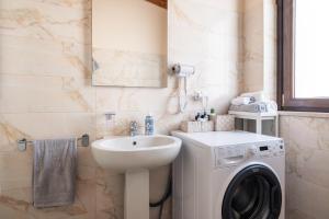 a bathroom with a washing machine and a sink at PinetoAlba Country House in Scerne