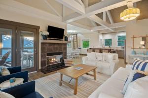 a living room with white furniture and a fireplace at Captain's Quarters in Smithville