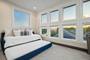 a bedroom with windows and a bed with white sheets at Captain's Quarters in Smithville +78 photos