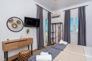 a bedroom with a bed and a desk and a television at Nikos Hotel in Karterados