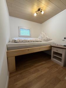 a bed in a room with a window at Ferienhaus Waldgeflüster in Limbach