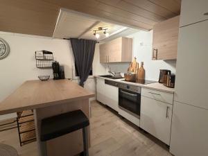 a kitchen with white cabinets and a wooden counter top at Ferienhaus Waldgeflüster in Limbach