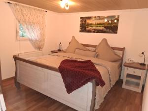 a bedroom with a large bed with avertisementatronatronstrationstrationstration at Ferienhaus Waldgeflüster in Limbach