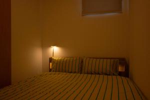 a bedroom with a bed with a lamp on it at HIKARIE Modern Stay Toyama in Toyama