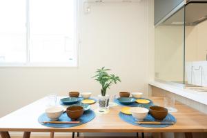 a wooden table with blue plates and bowls on it at HIKARIE Modern Stay Toyama in Toyama