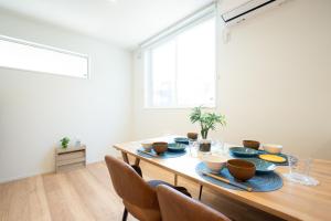 a dining room with a wooden table with blue dishes on it at HIKARIE Modern Stay Toyama in Toyama +41 photos
