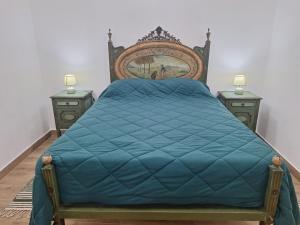 a bedroom with a bed with a blue comforter at D. TERESINHA in Vila de Frades