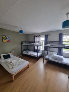 a room with three bunk beds in it at Rougey Lodge Hostel in Bundoran +69 photos
