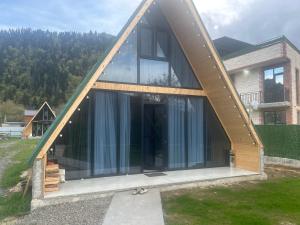 a house with a pointed roof with glass windows at Cottage Godzia in Sadgeri
