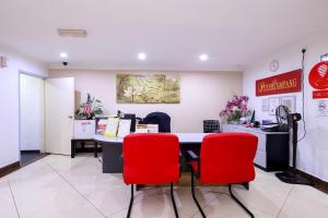 a waiting room with a table and red chairs at Puteri Ampang Hotel in Ampang