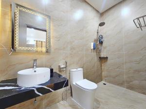 a bathroom with a sink and a toilet and a mirror at Serene Residence in Vientiane +58 photos