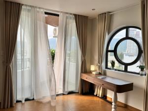 a room with a desk in front of a window at An House Son Tra in Danang