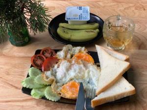 a plate of food with eggs and bread and vegetables at Sapa Tom's Hotel in Sapa +40 photos