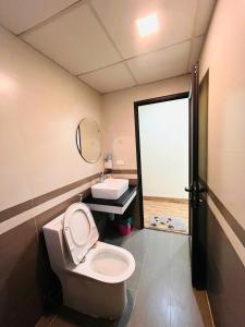 a bathroom with a toilet and a sink and a mirror at Sapa Tom's Hotel in Sapa