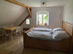 a bedroom with a bed and a table with chairs at Kafírna Ovesné Kladruby in Ovesné Kladruby