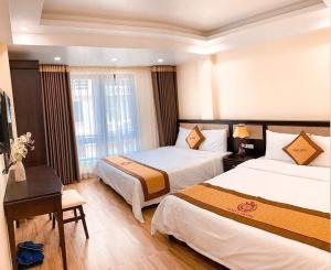a hotel room with two beds and a window at Sapa Tom's Hotel in Sapa