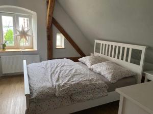 a bedroom with a white bed and a window at Kafírna Ovesné Kladruby in Ovesné Kladruby