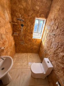 a stone bathroom with a toilet and a sink at DANA First View Hotel in Dana +71 photos