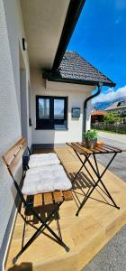 a patio with a table and a chair and a table at AERO Apartmaji Lesce-Bled in Lesce