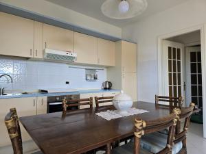 a kitchen with a wooden table with chairs and a kitchen counter at Casa Limone by Affitti Brevi Liguria in Borgio Verezzi